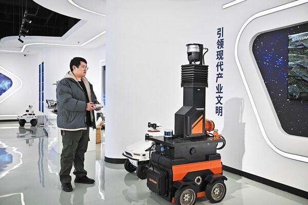 A staff member of Tianjin Siasun Intelligent Technology operates a mine inspection robot in the Beijing-Tianjin Zhongguancun Tech Town in Tianjin.